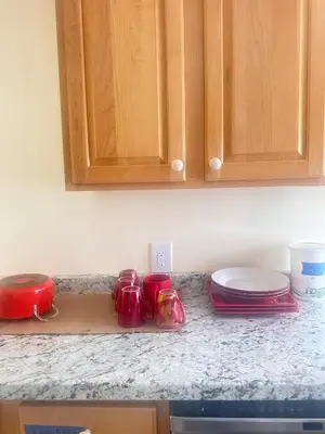 a kitchen counter with red cups and plates on it at Comfortable 3BR, 2BA Perfect for Families! in Mechanicsburg