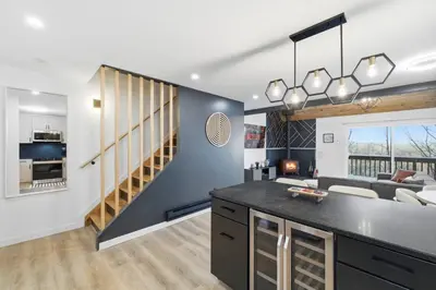 a kitchen and living room with a staircase in a house at Ski in Ski out on Camelback Mountain - Game Room! in Tannersville