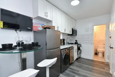 a kitchen with a stainless steel refrigerator and a sink at Cozy 1BR in Central Manhattan W Private Terrace in New York