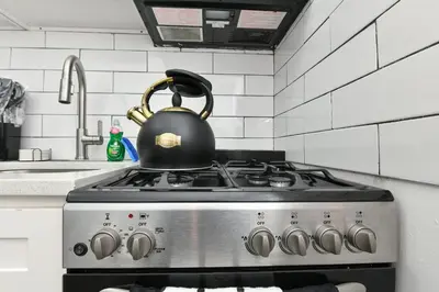 a tea kettle on top of a stove in a kitchen at Cozy 1BR in Central Manhattan W Private Terrace in New York