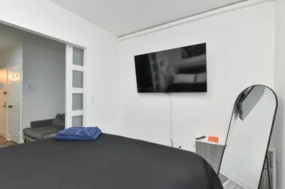 a bedroom with a black bed and a mirror at Cozy 1BR in Central Manhattan W Private Terrace in New York