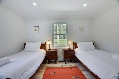 two twin beds in a room with a window at Poconos Lakefront Retreat | * Hot Tub * Arcades * in Long Pond