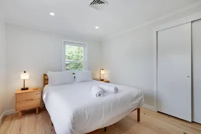 a white bedroom with a bed and a window at Poconos Lakefront Retreat | * Hot Tub * Arcades * in Long Pond