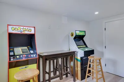 a room with a pinball machine and a bar with stools at Poconos Lakefront Retreat | * Hot Tub * Arcades * in Long Pond