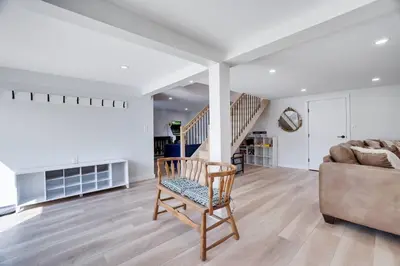 a living room with a chair and a couch at Poconos Lakefront Retreat | * Hot Tub * Arcades * in Long Pond
