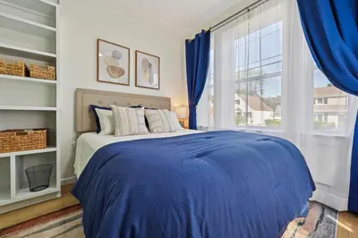 a bedroom with a blue bed and a window at The Hamilton Elm in Teaneck