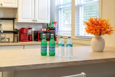 three bottles of soda sitting on a counter in a kitchen at The Hamilton Elm in Teaneck