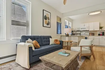 a living room with a blue couch and a table at The Hamilton Elm in Teaneck