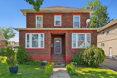 a red brick house with a purple door at The Hamilton Elm in Teaneck