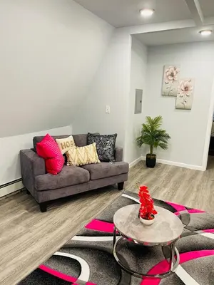 a living room with a couch and a table at Xceptional homes in East Orange