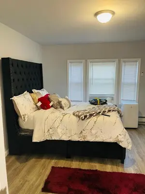 a bedroom with a large bed with a black headboard at Xceptional homes in East Orange