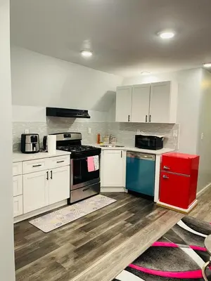 a kitchen with white cabinets and a red appliance at Xceptional homes in East Orange