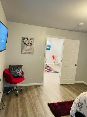 a living room with a red chair and a door at Xceptional homes in East Orange