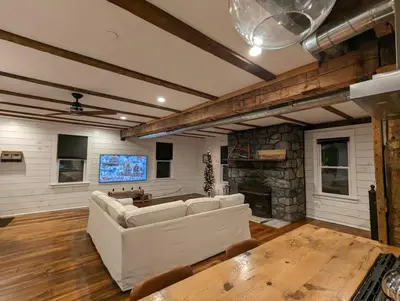 a living room with a white couch and a stone fireplace at Carriage House Apartment Close to Legoland NY in Goshen