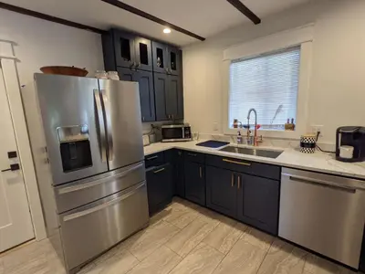 a kitchen with blue cabinets and a stainless steel refrigerator at Carriage House Apartment Close to Legoland NY in Goshen