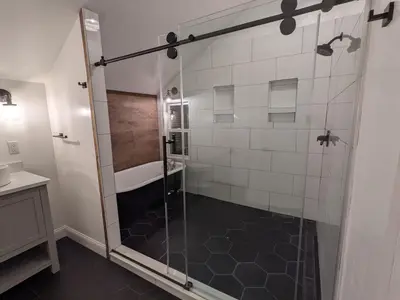 a bathroom with a shower with a sink and a tub at Hay Loft in Historic Barn - 4 Minutes to Legoland in Goshen