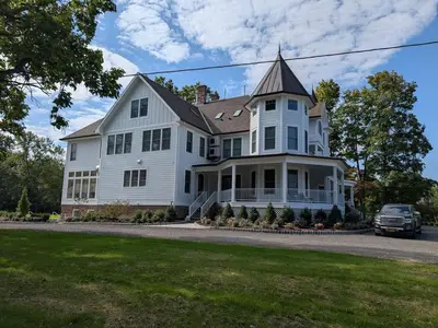 a white house with a car parked in front of it at Parkway House Goshen Bed And Breakfast Suite 2 in Goshen