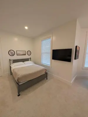 a bedroom with a bed and a flat screen tv at Parkway House Goshen Bed And Breakfast Suite 2 in Goshen