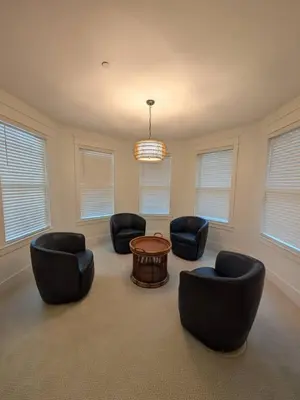 a living room with chairs and a table and windows at Parkway House Goshen Bed And Breakfast Suite 2 in Goshen