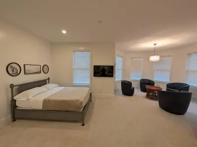 a bedroom with a bed and two chairs and a table at Parkway House Goshen Bed And Breakfast Suite 2 in Goshen