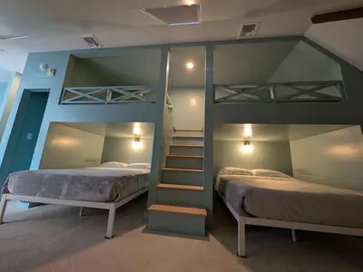 a bedroom with two bunk beds and a staircase at Parkway House Goshen Bed And Breakfast Suite 5 in Goshen