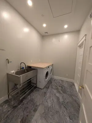 a laundry room with a sink and a washing machine at Parkway House Goshen Bed And Breakfast Suite 5 in Goshen