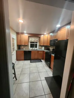 a kitchen with wooden cabinets and black appliances at Lansdowne Gem in Lansdowne