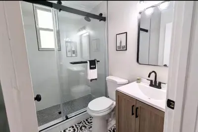 a bathroom with a shower and a toilet and a sink at Cozy 3 Bedrooms Spacious Comfort in Orange