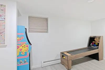 a room with a refrigerator and a table with a video game at The Harper Loft in Hoboken