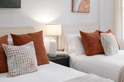 two beds with pillows and a lamp on a table at The Harper Loft in Hoboken