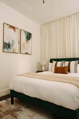 a bedroom with a large bed and two pictures on the wall at The Caleb Loft in Hoboken
