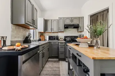 a kitchen with gray cabinets and a wooden counter top at The Caleb Loft in Hoboken