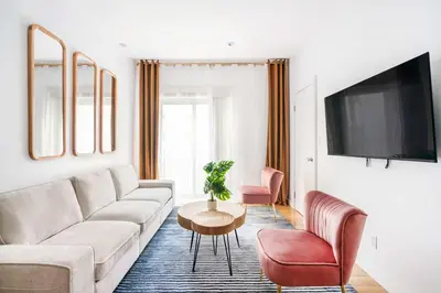 a living room with a couch and a table and chairs at 26A-2 Spacious brand new Fully Furnished 2-Bedroom in Prime Murray Hill Move-In Ready in New York