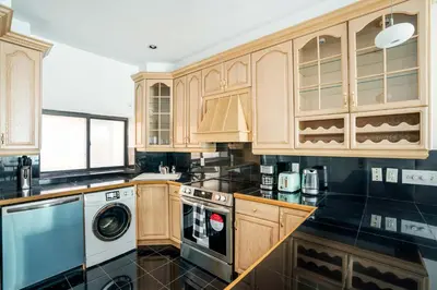 a kitchen with wooden cabinets and a washer and dryer at 26A-2 Spacious brand new Fully Furnished 2-Bedroom in Prime Murray Hill Move-In Ready in New York