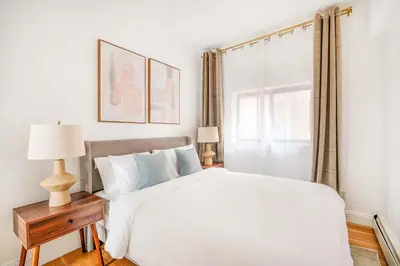 a white bedroom with a bed and a window at 26A-2 Spacious brand new Fully Furnished 2-Bedroom in Prime Murray Hill Move-In Ready in New York