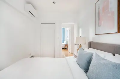 a white bedroom with a bed and a couch at 26A-2 Spacious brand new Fully Furnished 2-Bedroom in Prime Murray Hill Move-In Ready in New York