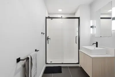 a white bathroom with a shower and a sink at Cozy modern studio in prime area in Philadelphia
