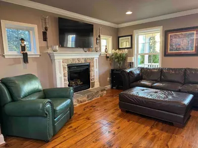 a living room with leather furniture and a fireplace at Charming Farmhouse In Quarryville,PA in Quarryville