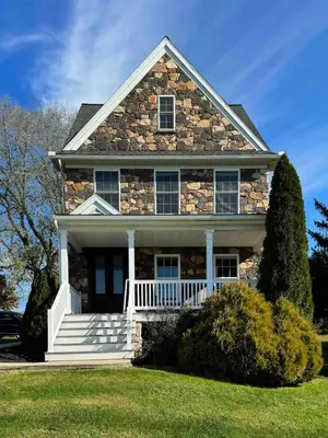 a stone house with a white porch and stairs at Charming Farmhouse In Quarryville,PA in Quarryville