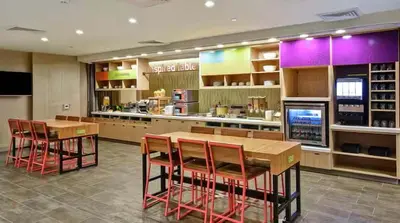 a restaurant with tables and chairs in a kitchen at Home2 Suites by Hilton in Mechanicsburg
