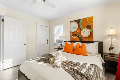 a bedroom with a bed with orange pillows and a painting at Family Retreat Near NYC w/ Parking & Views in Hackensack