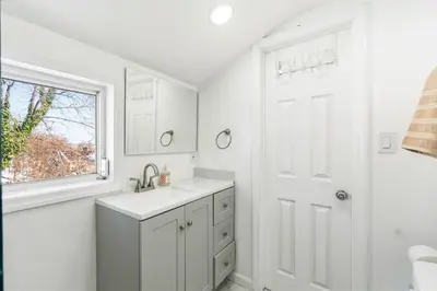 a white bathroom with a sink and a window at Family Retreat Near NYC w/ Parking & Views in Hackensack