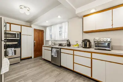 a kitchen with white cabinets and wooden floors at Family Retreat Near NYC w/ Parking & Views in Hackensack