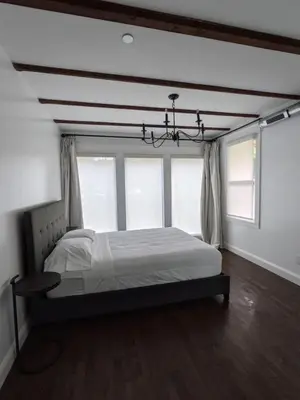 a bedroom with a bed and a chandelier at Historic Barn - 2 Bedroom Apartment Close To Legoland NY in Goshen