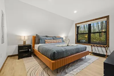 a bedroom with a bed and a large window at Hot Tub Sauna Spacious Backyard Luxury in Jim Thorpe