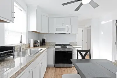 a kitchen with white cabinets and a ceiling fan at 17m to NYC,5 min to American Dream,2Parking Spaces in Carlstadt
