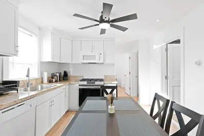 a kitchen with white cabinets and a ceiling fan at 17m to NYC,5 min to American Dream,2Parking Spaces in Carlstadt