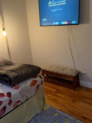 a room with two beds and a projection screen on the wall at Exclusive Home in Newark