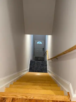 a hallway with stairs leading up to a door at Exclusive Home in Newark