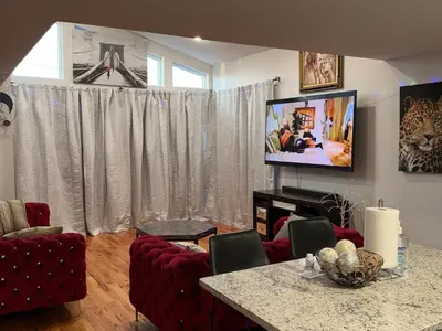 a living room with a television and a table and chairs at Exclusive Home in Newark